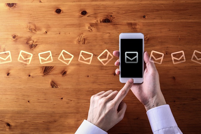 スマホの上を通過するメール